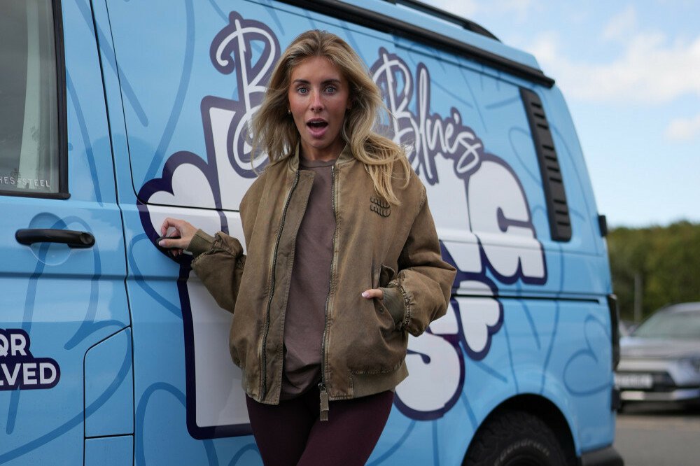 Bonnie Blue standing beside her signature blue bus